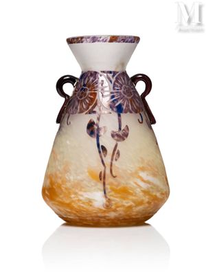 un vase en verre avec un tableau posé sur une table