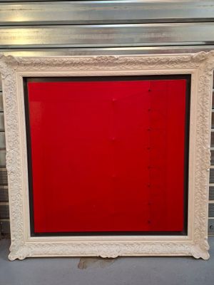 un vieux cadre photo avec une porte rouge devant un mur de briques