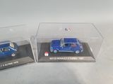 two miniature cars in a clear display case on a table