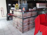 des tables et des chaises dans un restaurant doté d'un comptoir en briques et de chaises rouges