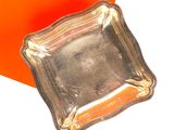 une assiette en argent posée sur une table orange et blanche