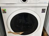 une machine à laver blanche posée sur une palette en bois