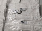 six white t - shirts wrapped in plastic on a table