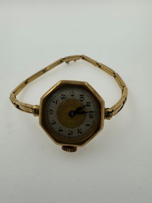 an image of a gold wrist watch on a white surface