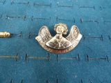 an image of a gold angel pin sitting on top of a blue cloth