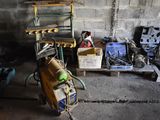 un tas d'outils dans un garage, à côté d'une étagère
