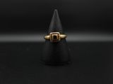 un gros plan d'une bague en or posée sur un cône noir