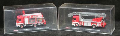 deux boîtes transparentes contenant un camion de pompiers rouge et un camion de pompiers blanc