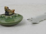 a small figurine of a cat and a fish in a bowl