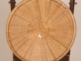 a wicker basket sitting on a wooden stand
