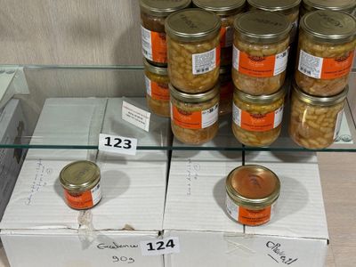 de nombreux bocaux de conserve exposés sur une étagère en verre
