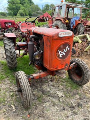 un tracteur rouge qui est garé dans la terre
