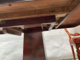 a close up of a wooden table with a chair underneath it