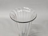 a clear glass vase with a black base on a white background