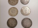 six different types of coins are displayed on a white surface