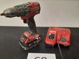 une perceuse et une batterie posées sur une table à côté d'un panneau
