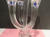 three glass candlesticks with blue eyes on them on a table