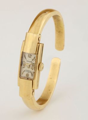 a close up of a gold wrist watch with a square face