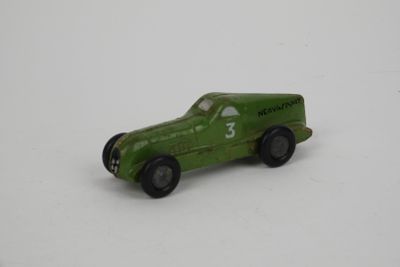 a green toy car that is sitting on a white surface