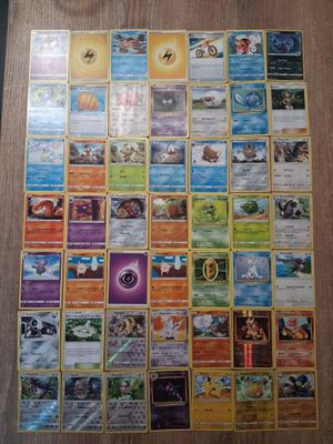 a large collection of pokemon cards sitting on top of a wooden table
