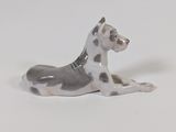 a figurine of a dog laying down on a white surface