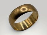 a close up of a gold ring on a white surface