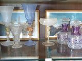 de nombreux vases en verre posés sur une étagère en verre dans une vitrine