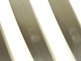 four knives are lined up in a row on a white surface