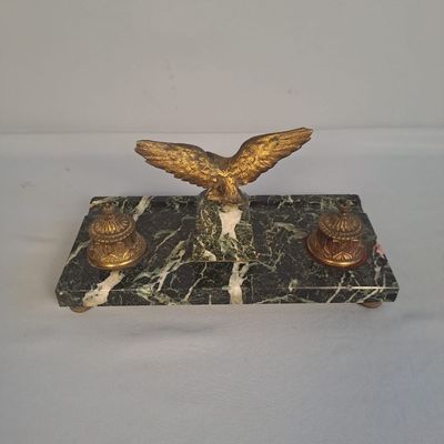 une statue d'aigle posée sur un socle en marbre