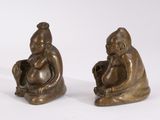 pair of bronze figurines of a baby sitting on a stool