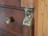 a wooden chest of drawers with brass handles on it