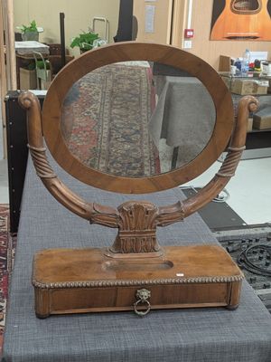 un miroir posé sur une table, à côté d'une valise