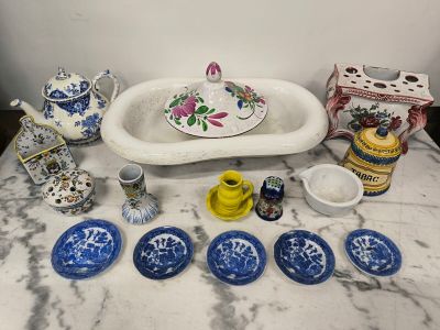 a table with a sink, plates, cups, and a teapot on it