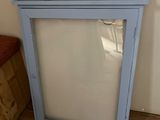 a small blue cabinet with a mirror on top of it