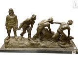 statue of a group of men working on a piece of metal