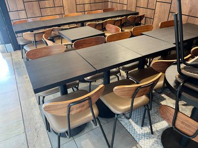 de nombreuses tables et chaises dans un restaurant où se trouve un parasol noir