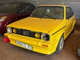 une voiture jaune garée à côté d'une voiture rouge dans un garage