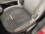 a dirty seat in the back of a car with a broken arm rest