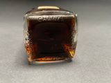 a bottle of whiskey sitting on a table next to a glass container