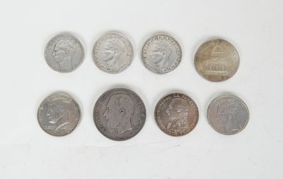 several different coins are arranged in a row on a white surface