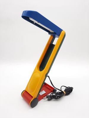 yellow, blue and red desk lamp on a white background