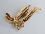 gold plated brooch with a leaf and flower design