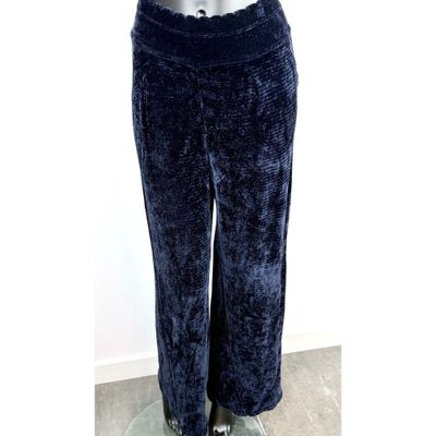 Cette femme porte un pantalon bleu et une chemise blanche.