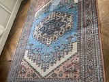 rug on the floor in a room with a bed and a window
