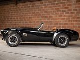 a black sports car parked in front of a brick wall