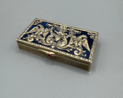 une boîte ancienne, argentée et bleue, ornée d'un motif