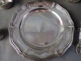 a silver plate on a table with silver utensils and spoons