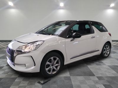 la petite voiture blanche est garée sur un carrelage à carreaux