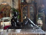 a statue of a woman sitting on a table in a living room