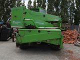 a green crane that is parked in a parking lot